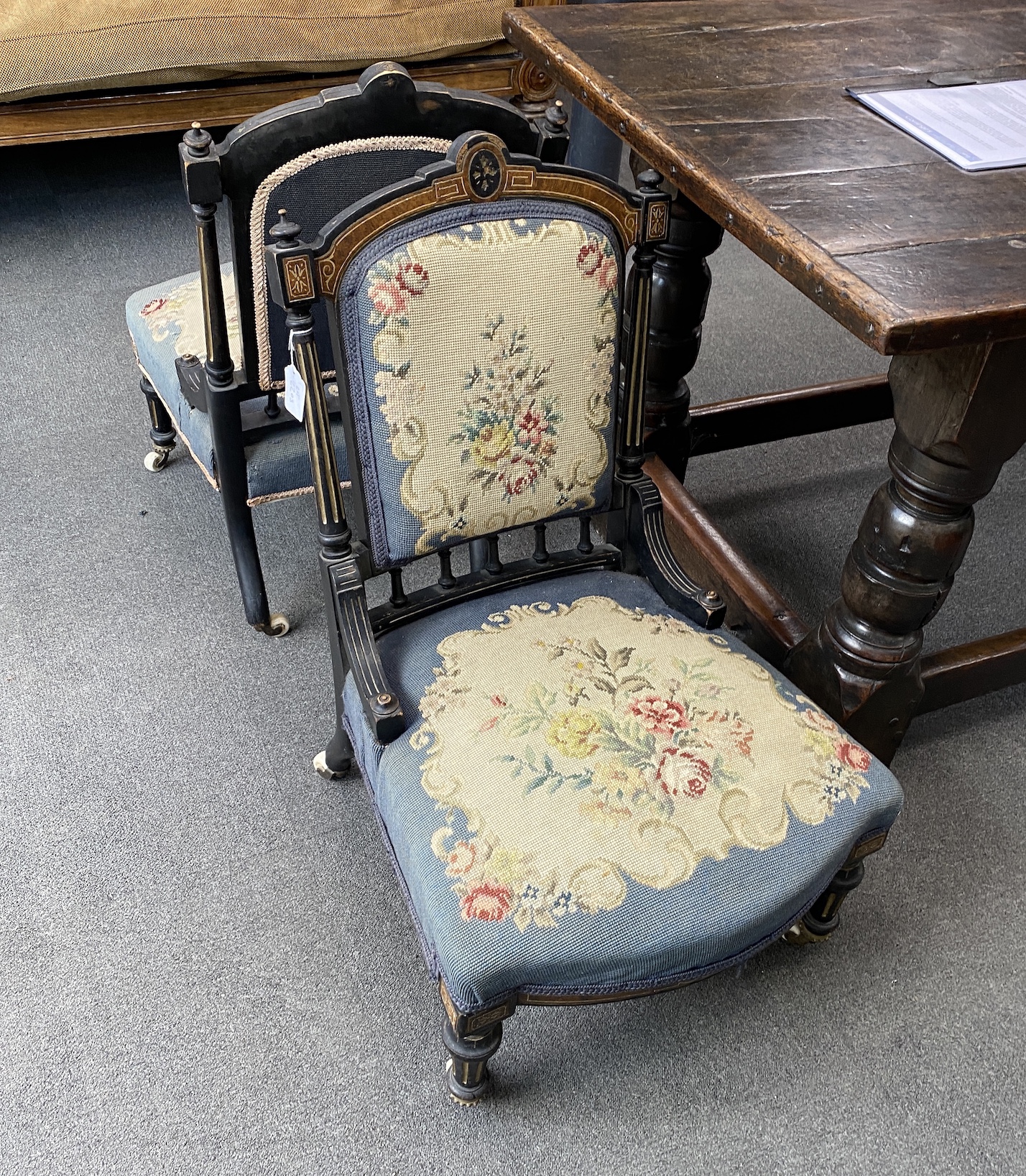 A pair of late Victorian ebonised and amboyna salon chairs with petit point upholstery, width 50cm, height 82cm